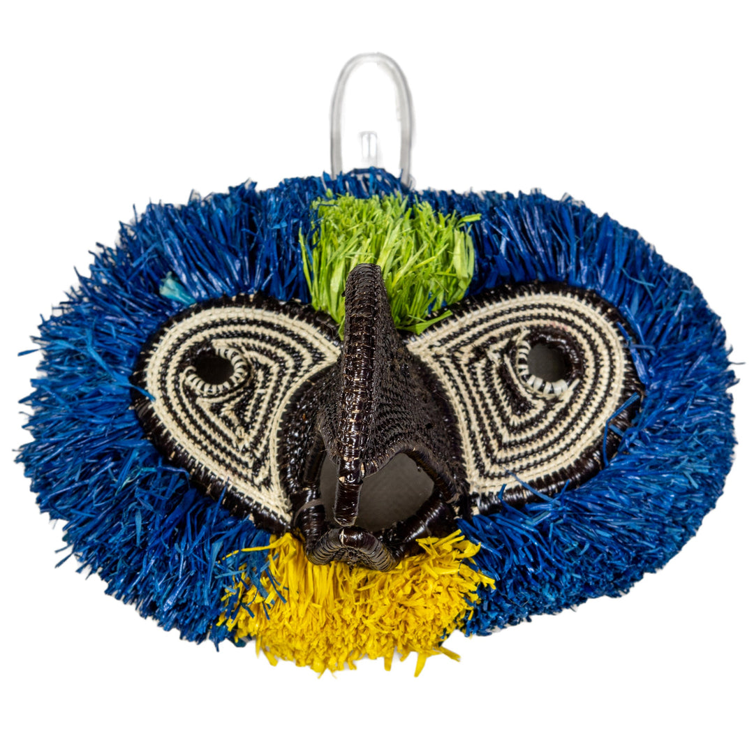 Woven owl mask with spiral eye panels, black beak, blue fringes, green tuft, yellow trim