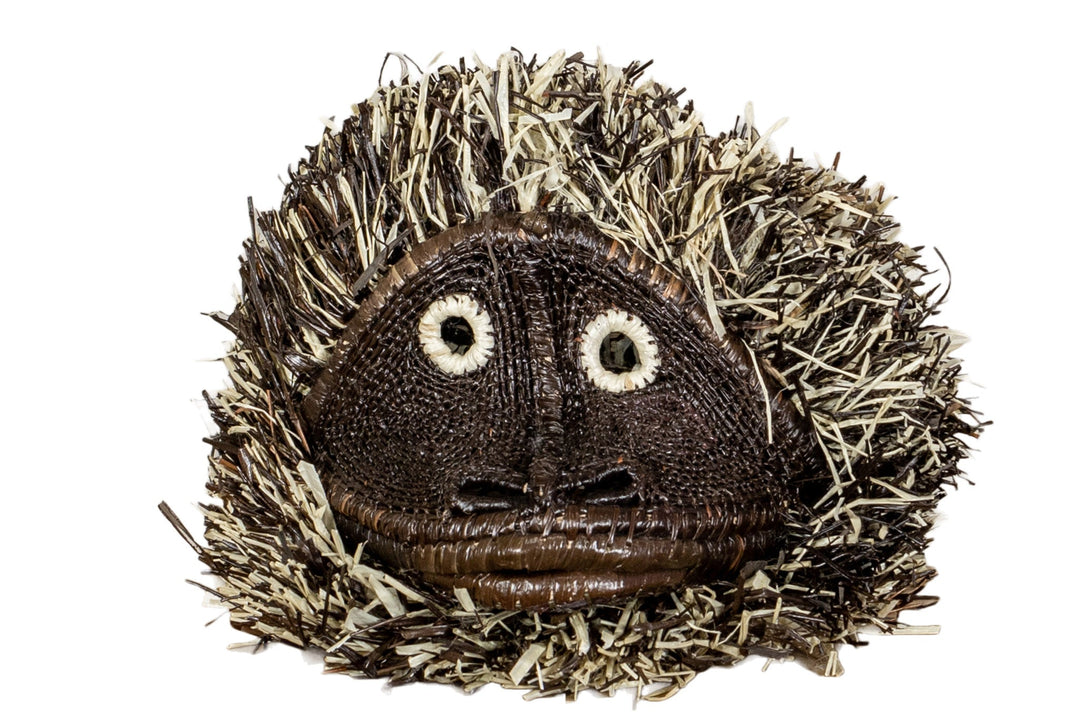Tufted capuchin monkey mask close-up with embroidered eyes and brown stitched mouth.