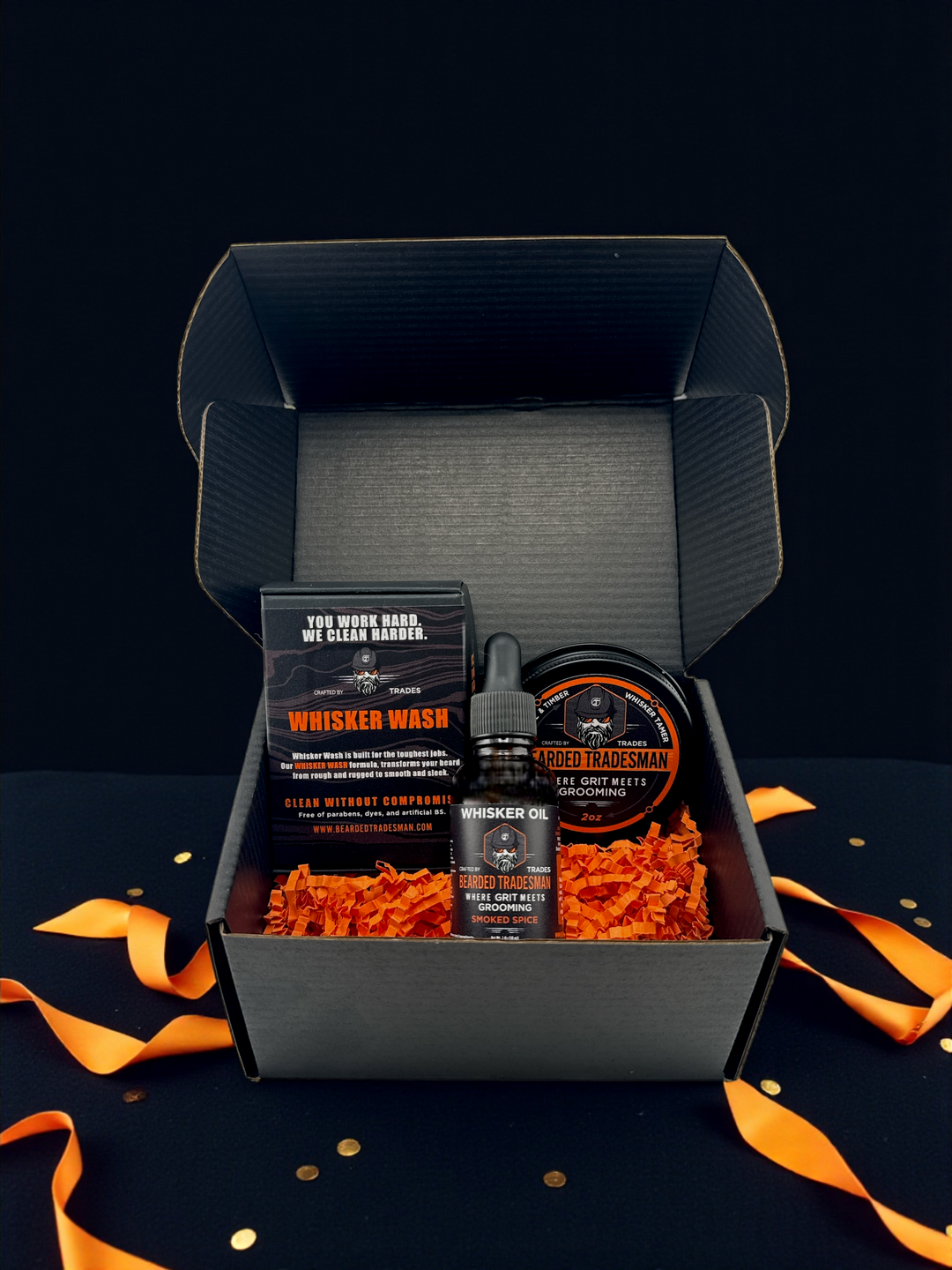 Beard grooming kit in open box with whisker wash, oil bottle, and grooming balm tin