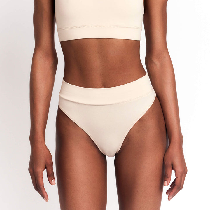 Cheeky tanga briefs in nude/latte, low-rise with minimal side coverage.