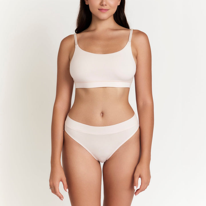 Cheeky tanga underwear in light cream, low-rise waistband and minimal coverage.