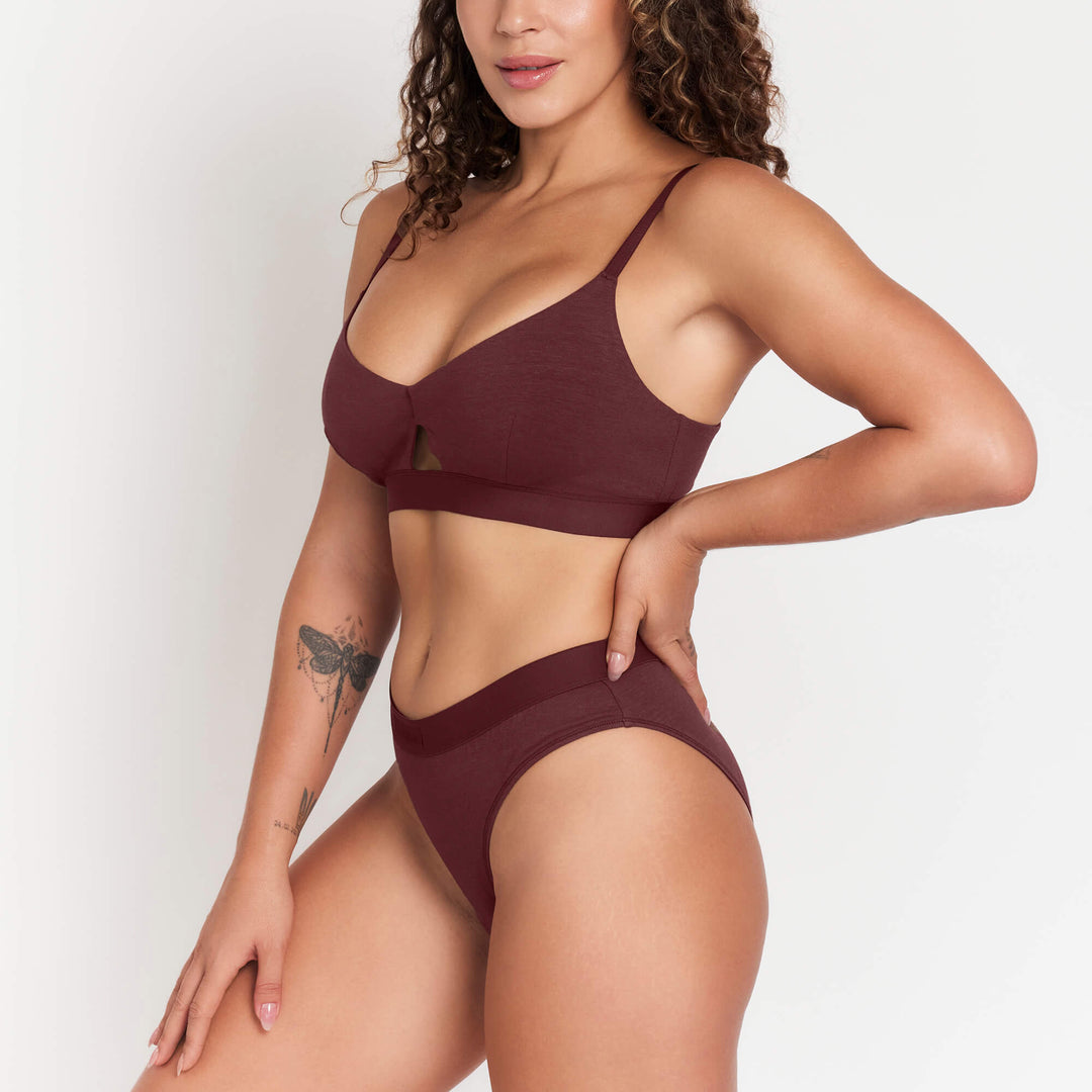 Burgundy mid-rise brief on model with matching bralette and wide waistband.