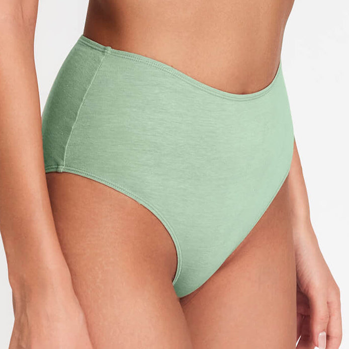 High-rise brief in light green with high-cut leg openings and curved seams, side view.