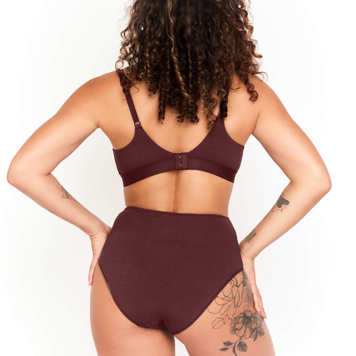 Dark maroon high-rise briefs on model, wide waistband and smooth seamless fit.