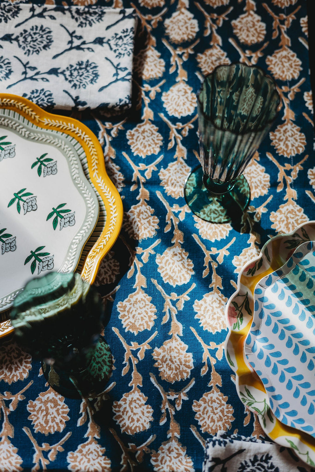 Linen runner fabric in ink blue with gold floral medallions and vine motifs, close-up