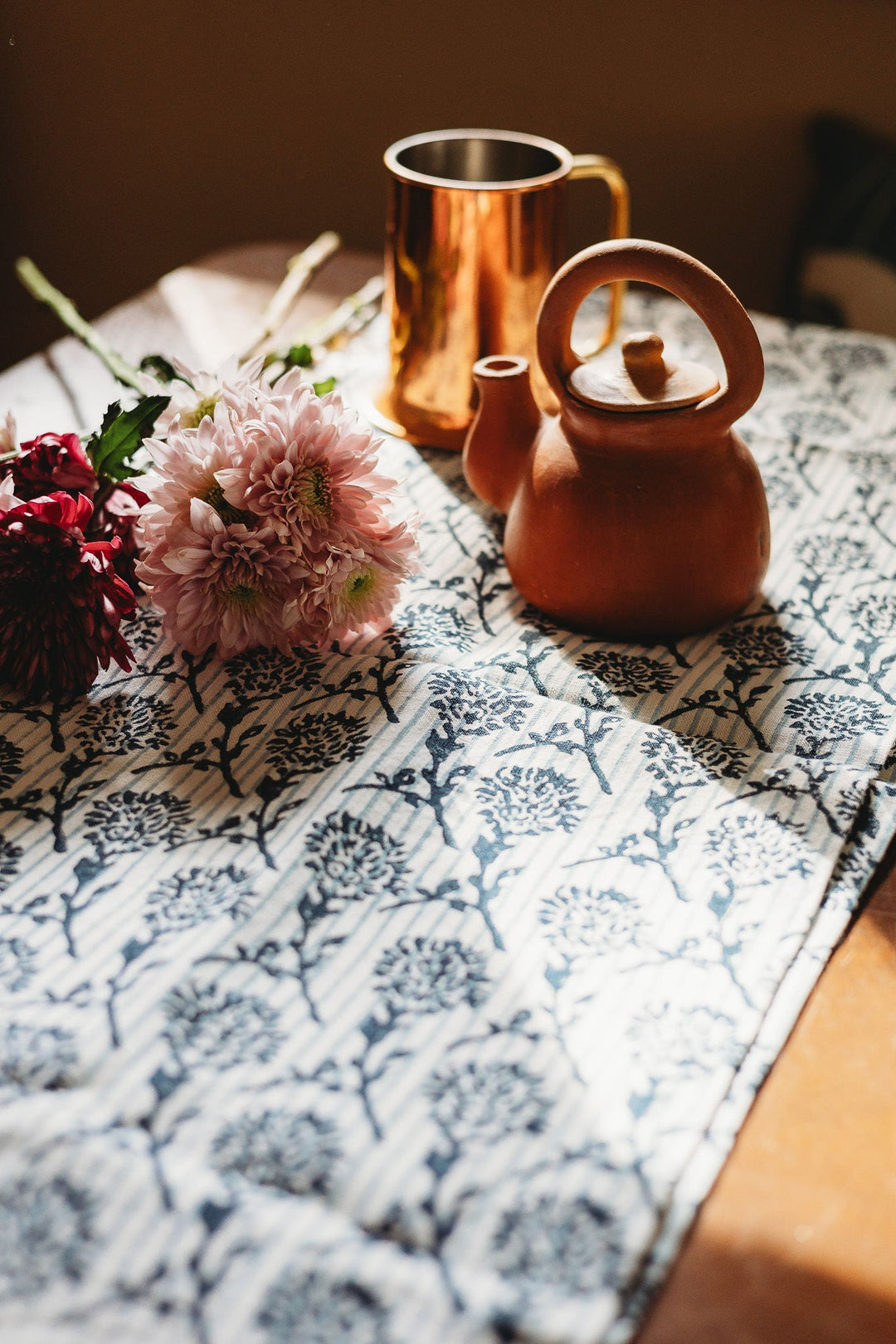 Hand-printed linen runner with blue botanical pattern on light ground texture