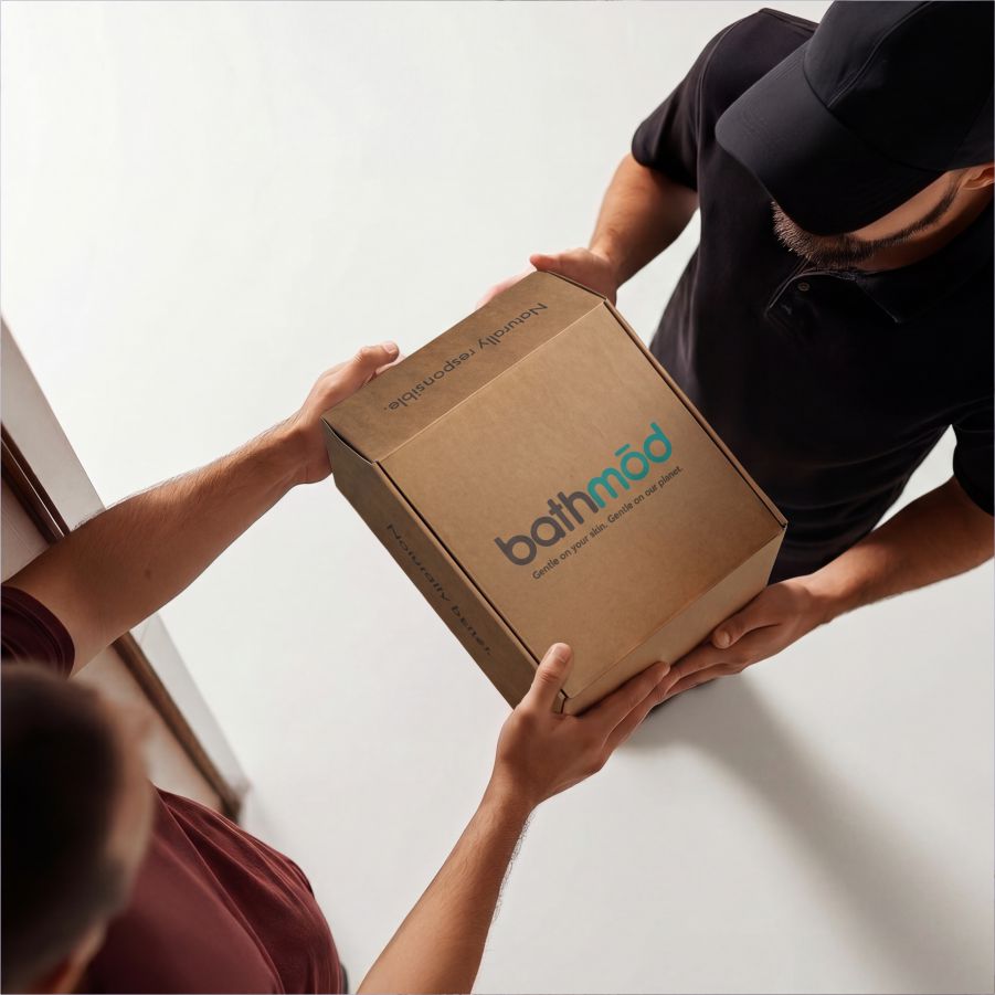 Four-pack bath mats in a branded cardboard box being handed between two people