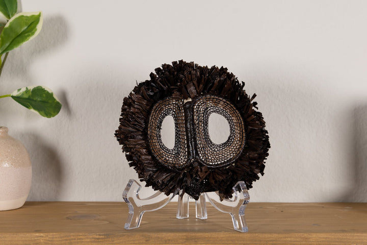Fish-themed owlet mask with dark woven fringe and two oval mesh eye cutouts