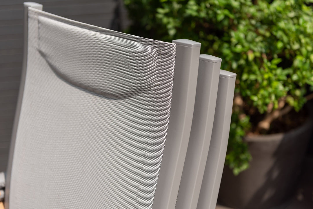 Close-up of gray outdoor dining chair backs with white mesh panels