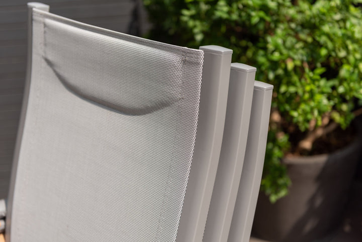 Close-up of gray outdoor dining chair backs with white mesh panels