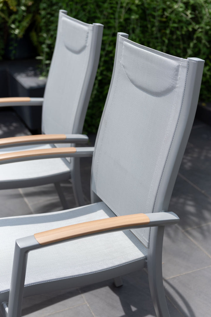 Pair of outdoor dining chairs with white mesh backs and light wood armrests