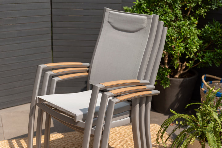 Outdoor dining chair with gray frame, white mesh seat, and light wood armrests