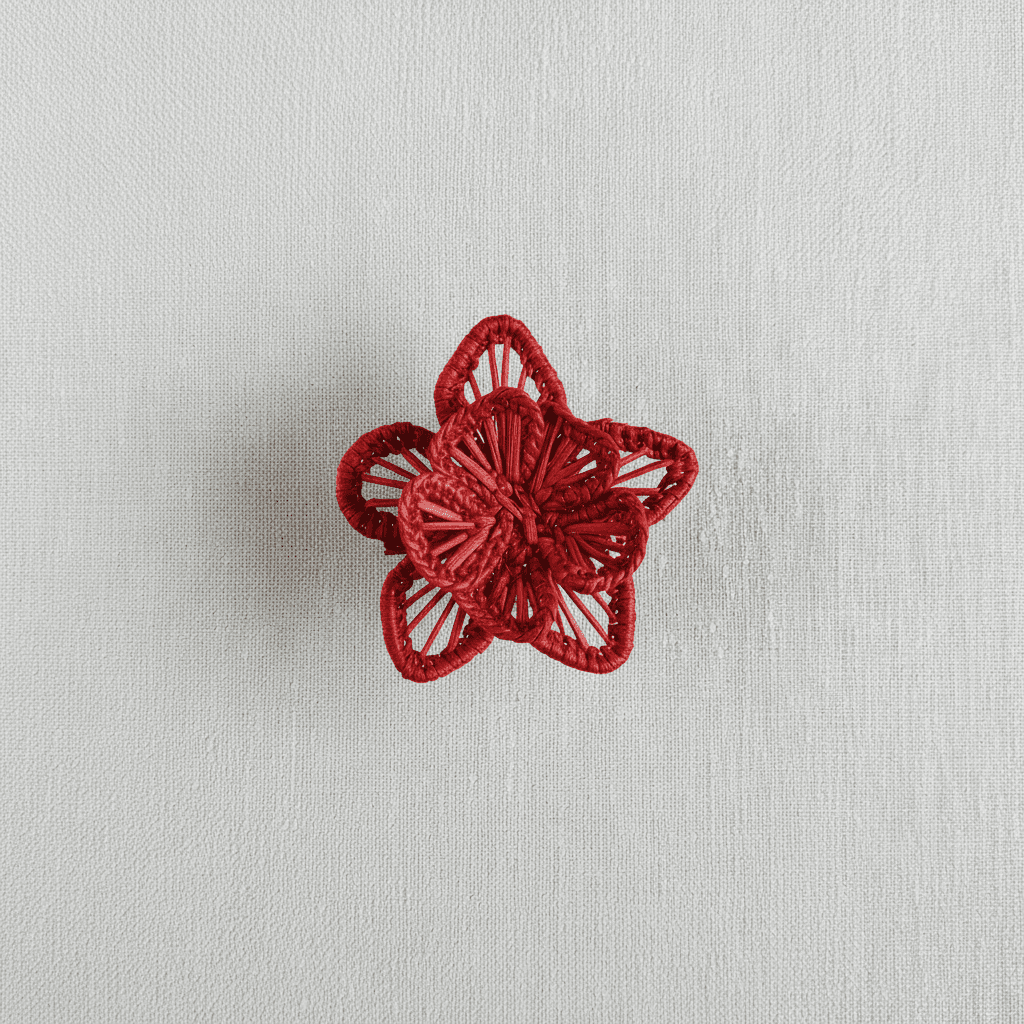 Handwoven star-flower napkin ring in dusty rose pink woven palm fibers