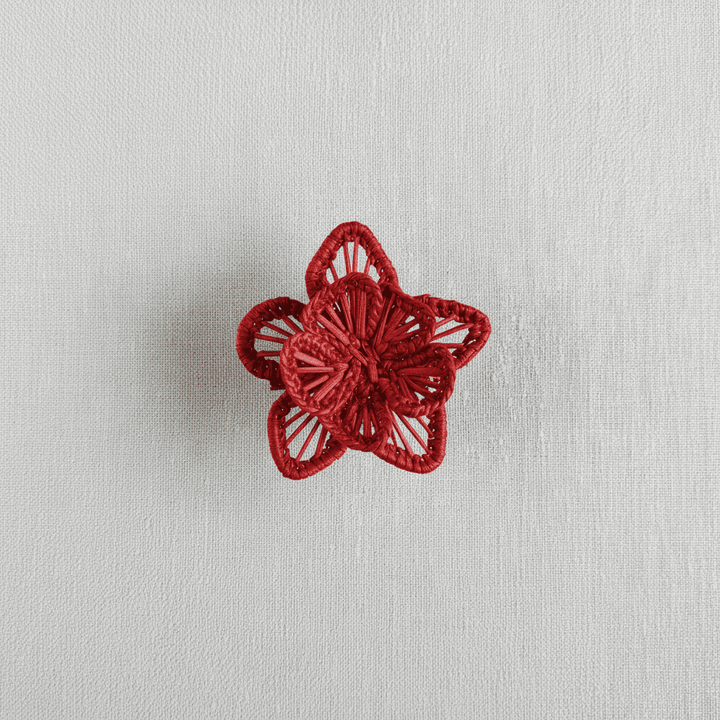 Handwoven star-flower napkin ring in dusty rose pink woven palm fibers