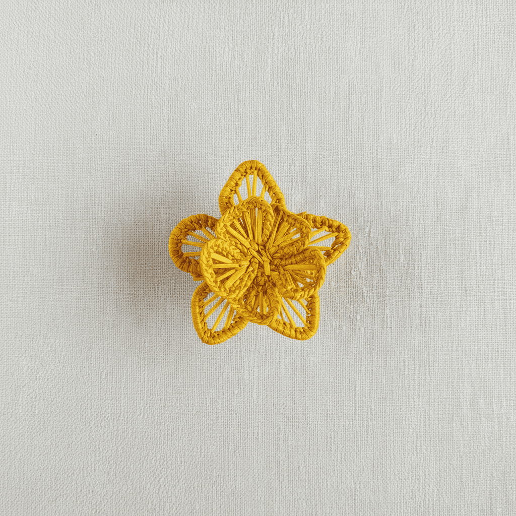 Handwoven star-flower napkin ring in light tan and peach thread accents