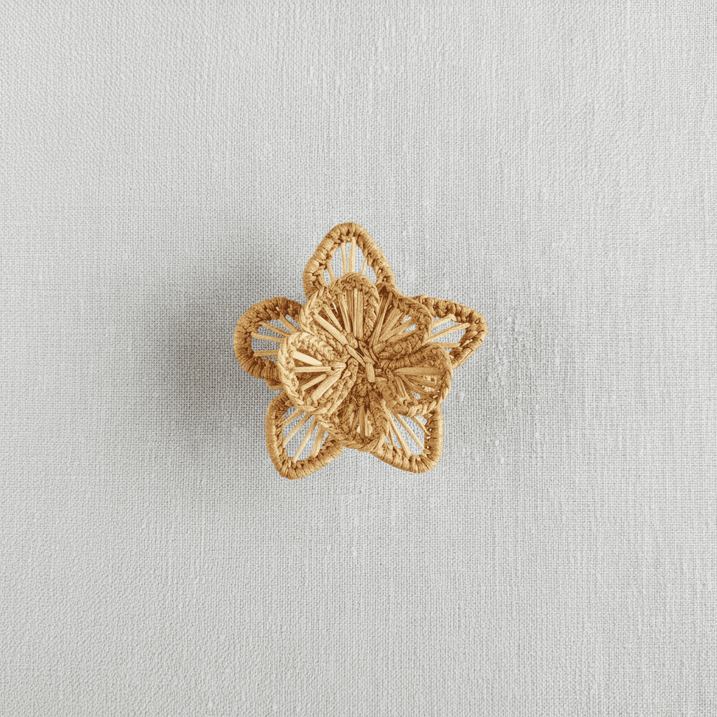Handwoven star-flower napkin ring in deep green woven palm fibers