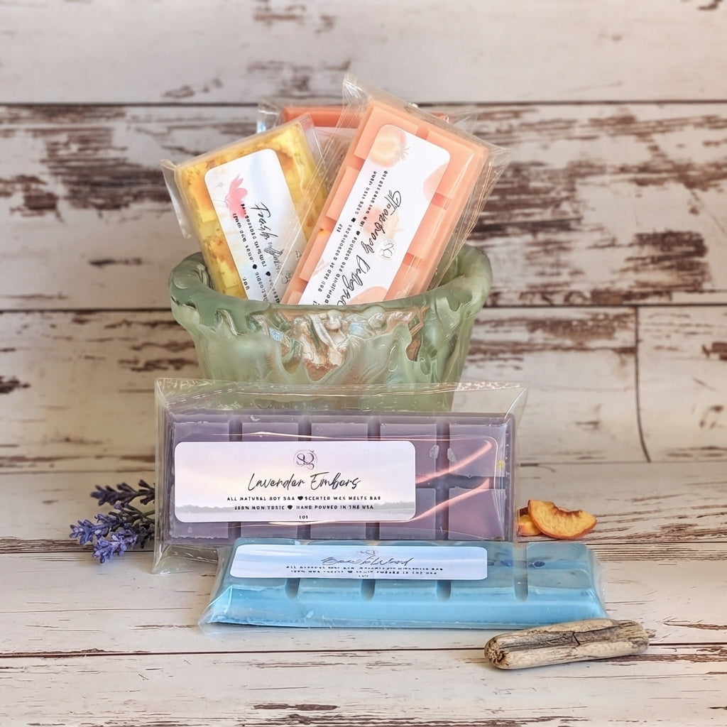 Assorted wax melt bars in pastel colors, packaged and arranged in a green bowl