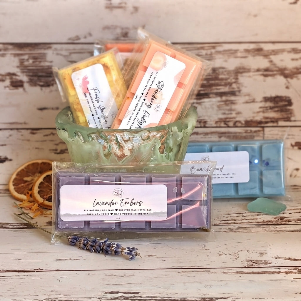 Wrapped wax melt bars in a green decorative cup, with scent labels visible