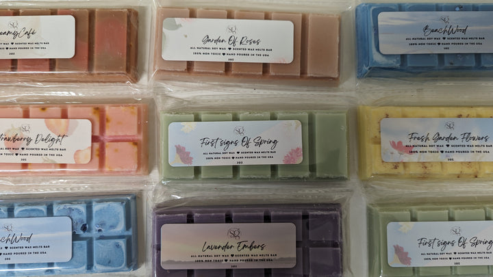 Multiple wax melts bars in clear containers, assorted colors and printed scent labels