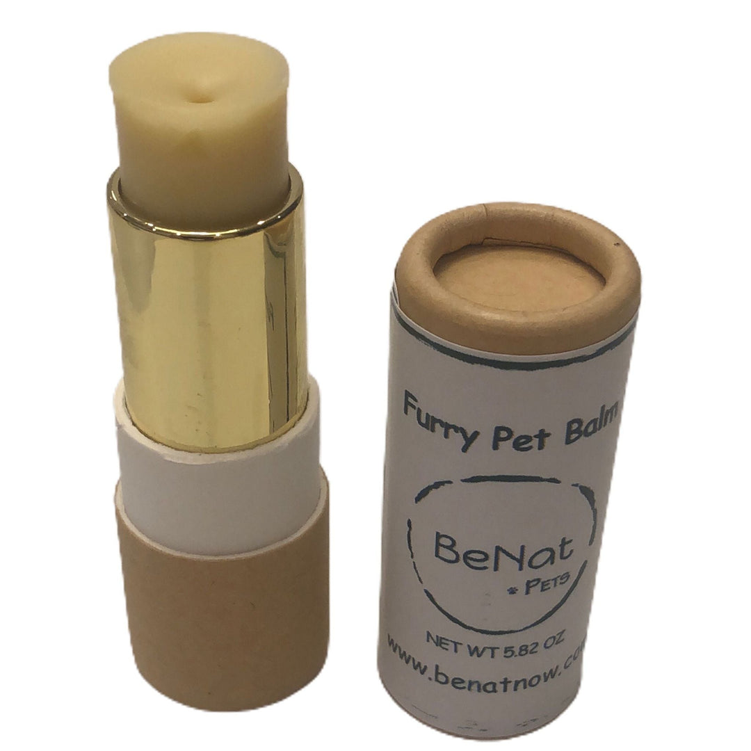 Pet balm stick in gold case next to small round tin with product label