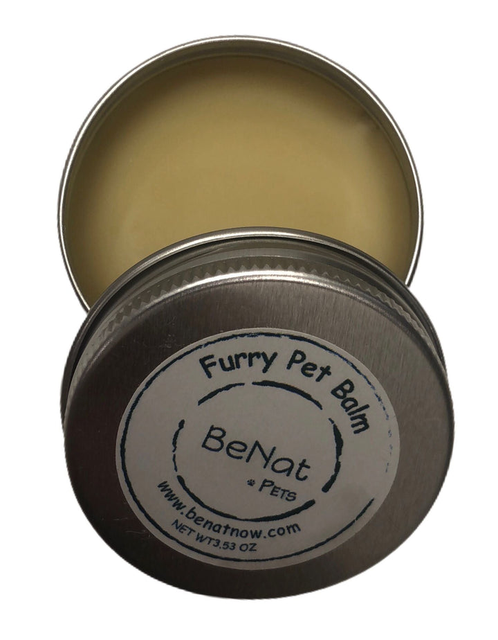 Round metal pet balm tin with brand label on lid, close-up view