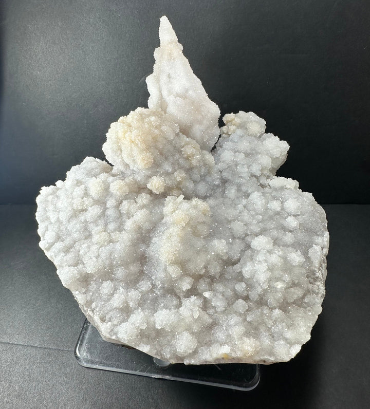 White druzy calcite cluster on gray agate base, free-standing on clear stand