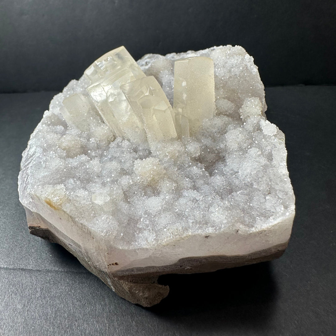 Calcite crystal cluster on white druzy agate, translucent pale cube crystals