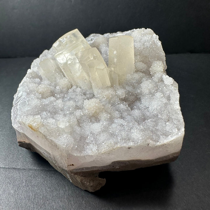 Calcite crystal cluster on white druzy agate, translucent pale cube crystals