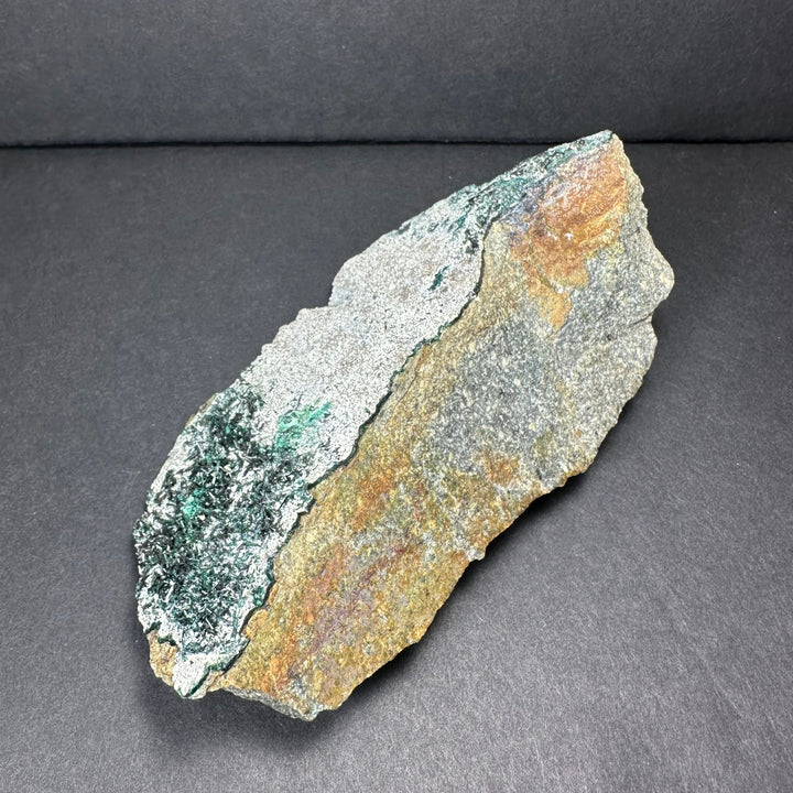 Epidote crystal cluster on matrix, green crystals with exposed rusty-brown rock edge