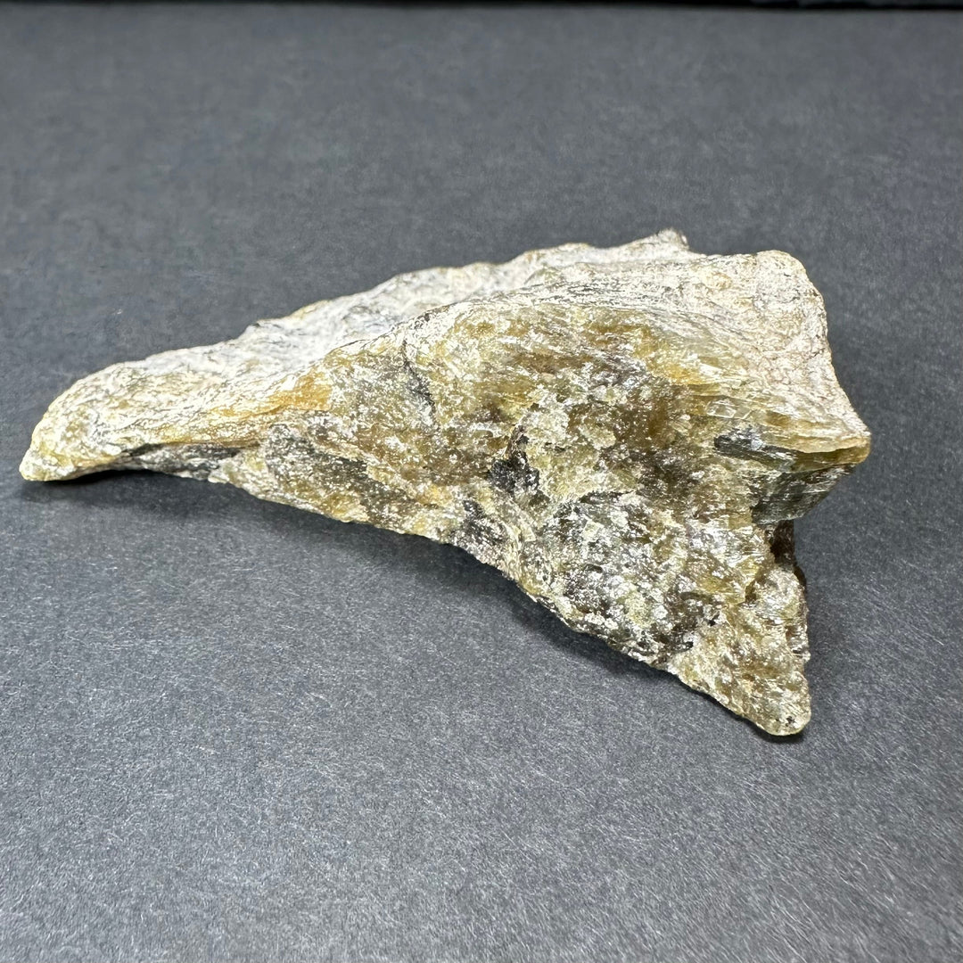 Labradorite rough stone, elongated and flat with gold-tinted highlights and speckles