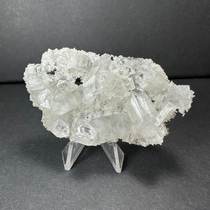 Clear apophyllite crystal cluster micro specimen with sharp white crystal facets on stand
