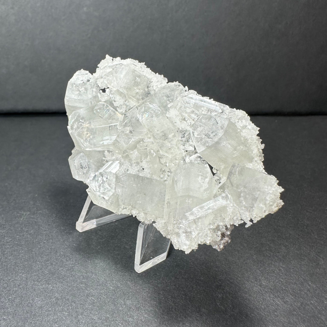 Clear apophyllite crystal cluster micro specimen with sparkling white crystal points on stand