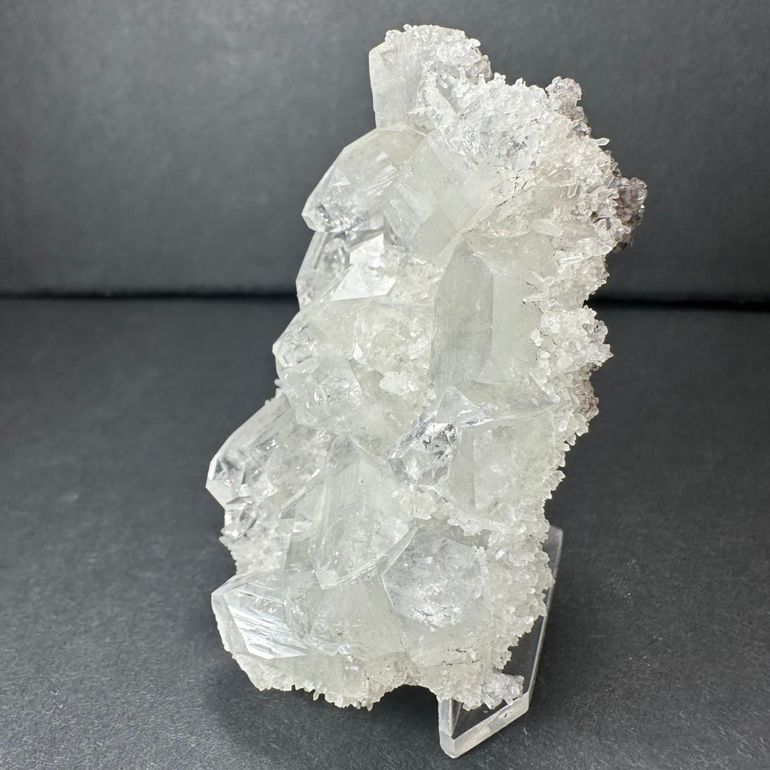 Clear apophyllite crystal cluster micro specimen with tall white crystal facets on stand