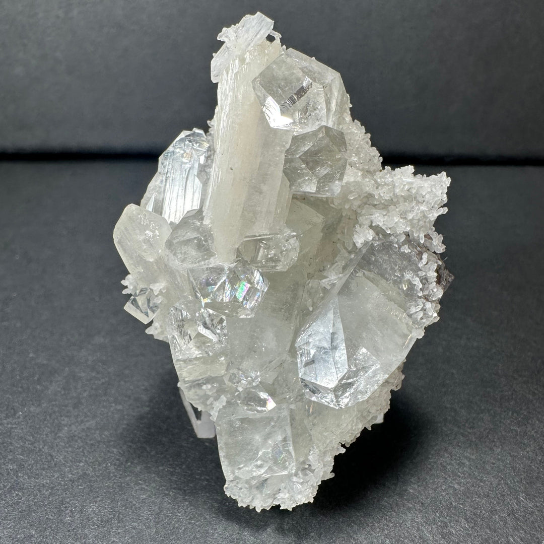 White stilbite and clear apophyllite crystal cluster, on angled clear stand