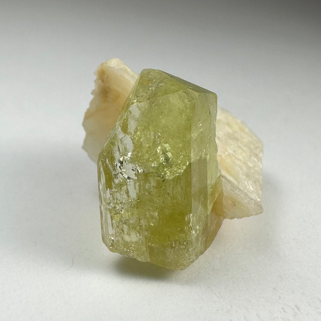 Green Brazilianite crystal with white Albite backing, natural rough faceted form