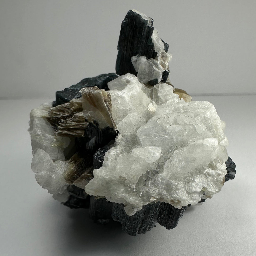 Mineral specimen with black tourmaline needles, thick white quartz, golden brown mica