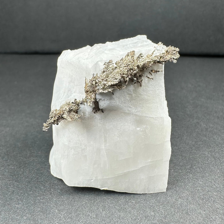 White calcite block with branching silver-gray dendrite detail across the surface