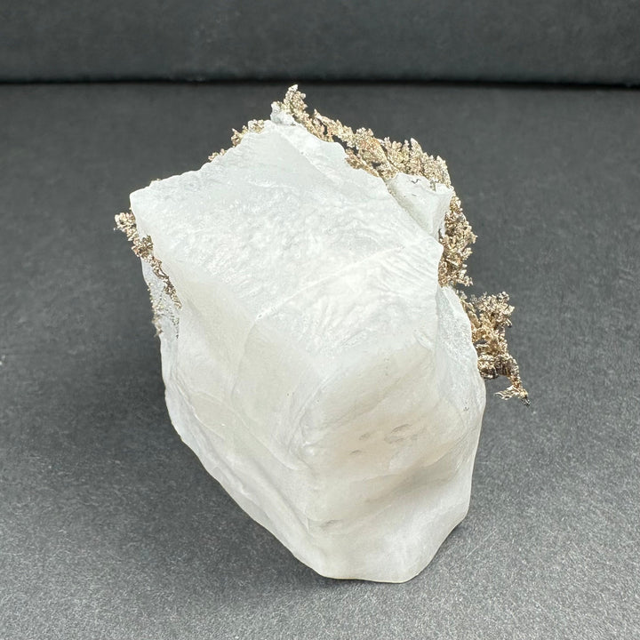 White calcite mineral specimen with silver-gray dendrite along the upper rim