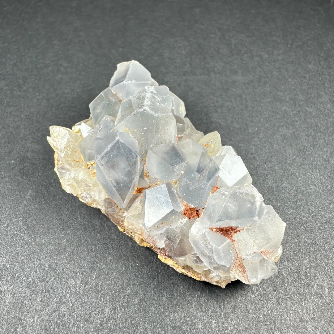 Celestite crystal cluster on tan matrix with pale blue translucent crystals and tiny orange spots