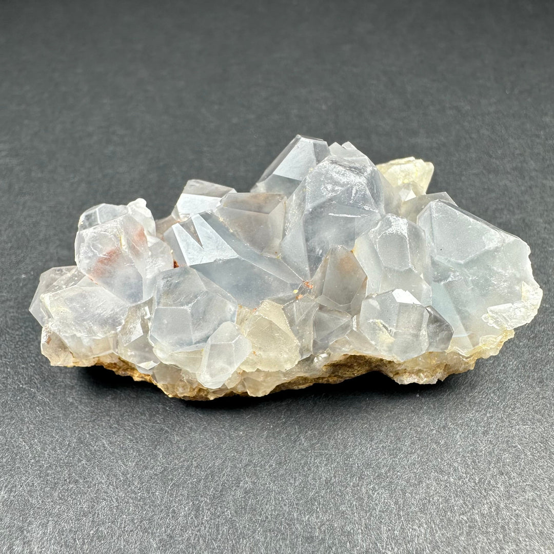 Celestite crystal cluster on tan matrix featuring many translucent pale blue prismatic crystals