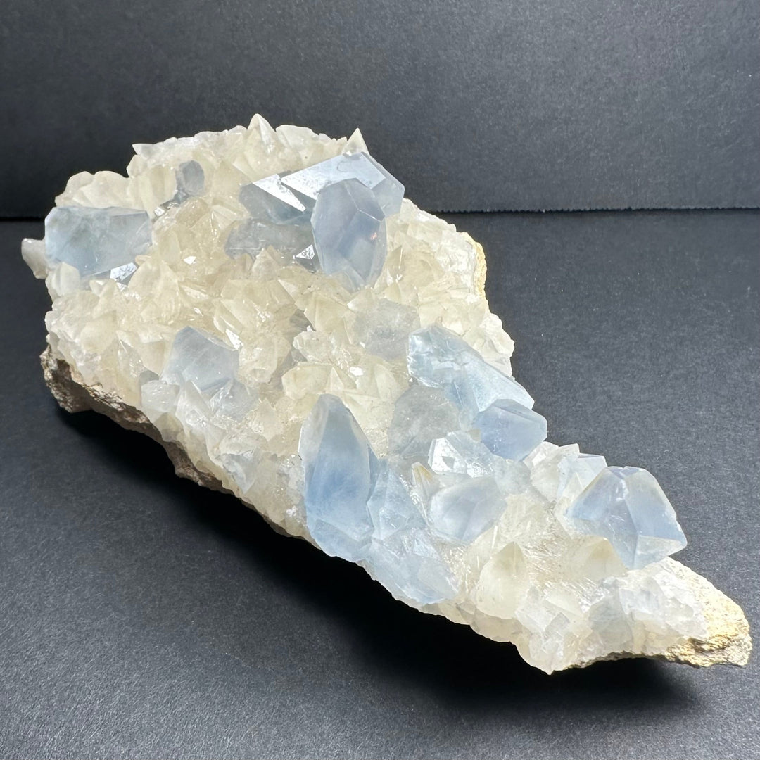 Blue and white crystal cluster specimen with large translucent facets and jagged base