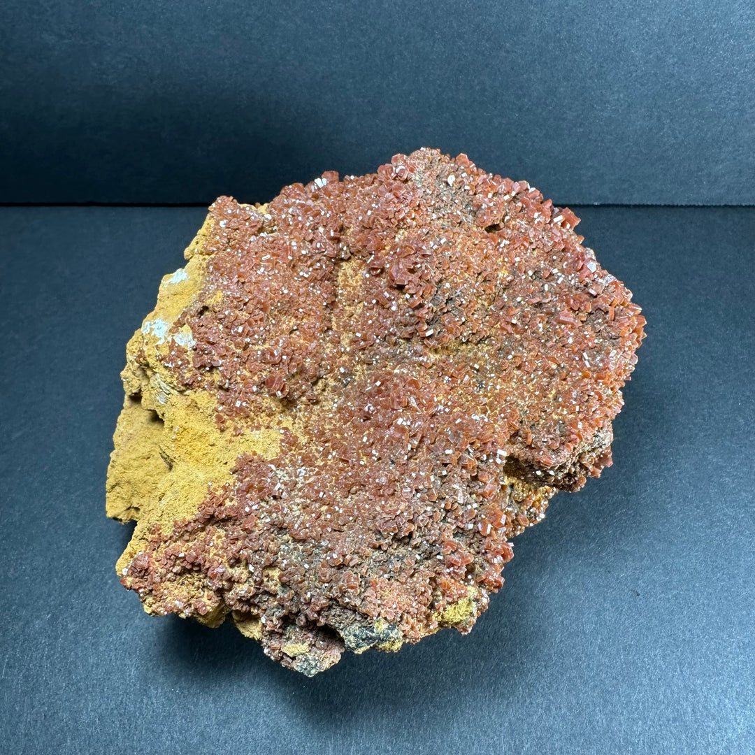 Vanadinite crystals on matrix, sparkly orange-red layer with yellow and gray rock