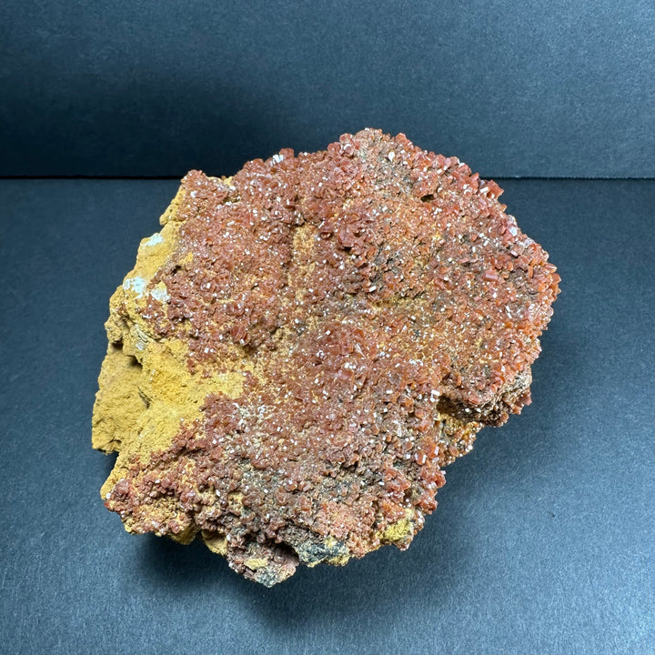 Vanadinite crystals on matrix, sparkly orange-red layer with yellow and gray rock