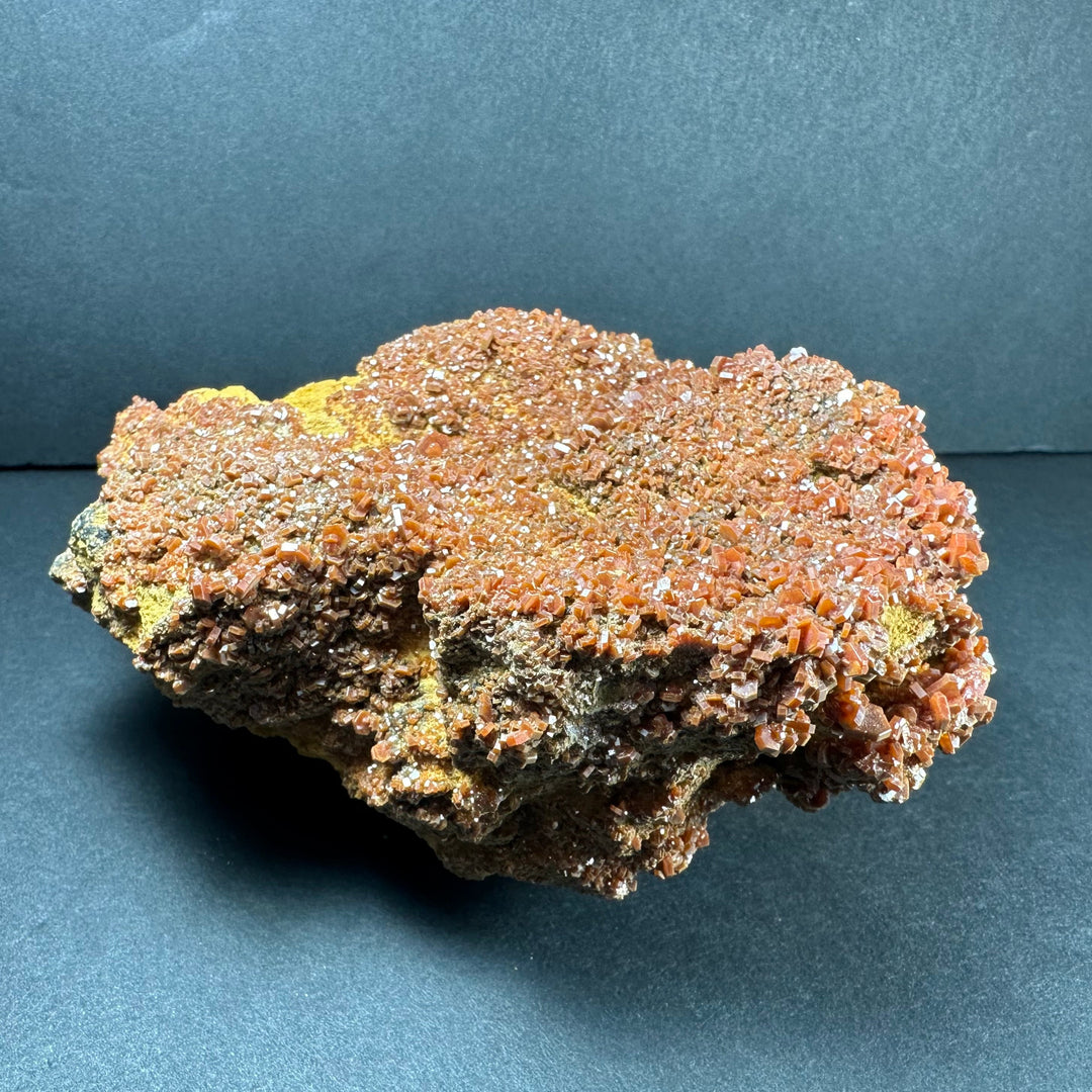 Vanadinite crystals on matrix, glittering orange-red crystals with greenish-yellow base