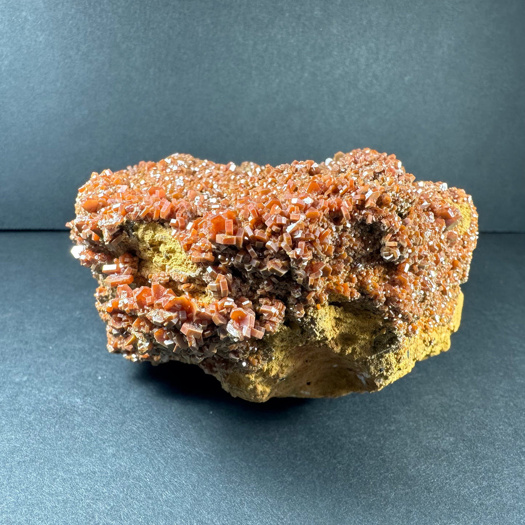 Vanadinite crystals on rock matrix, orange-red crystal clusters with yellow base