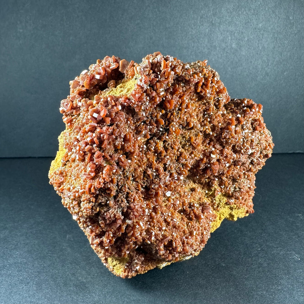 Vanadinite crystal specimen on matrix, dense copper-orange crystals over dark rock