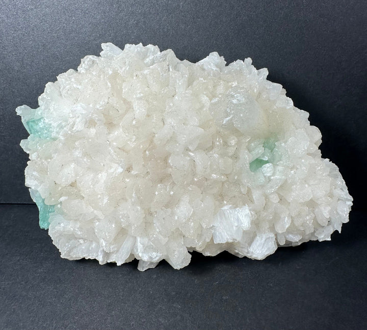 Mineral crystal cluster on matrix with white crystals and aqua-green band near edge