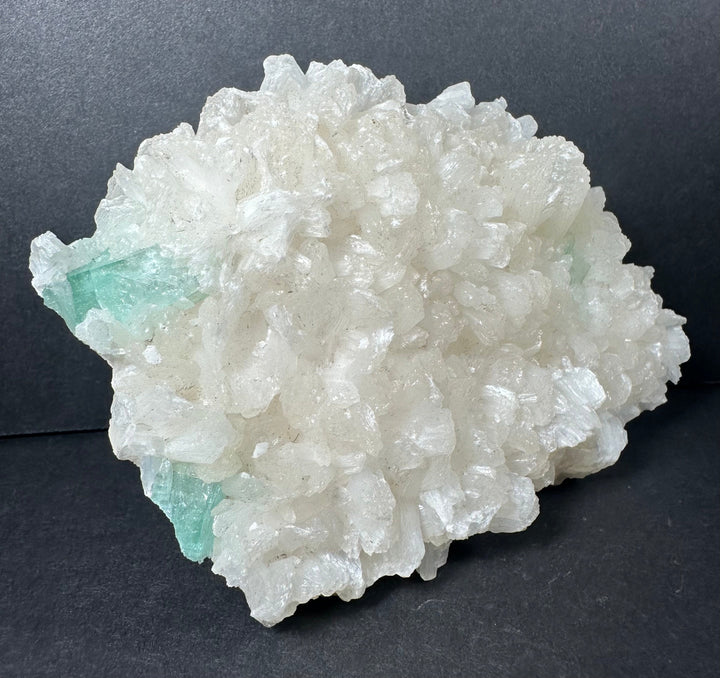 Mineral crystal cluster on matrix with white crystals and pale aqua-green spots