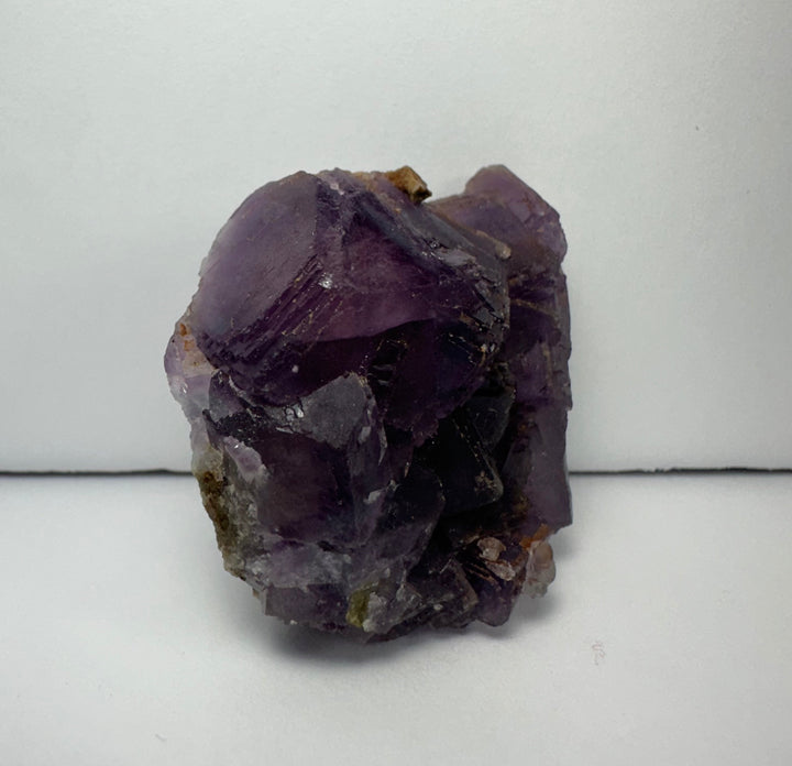 Purple cubic fluorite specimen on matrix, clustered crystals with dark core