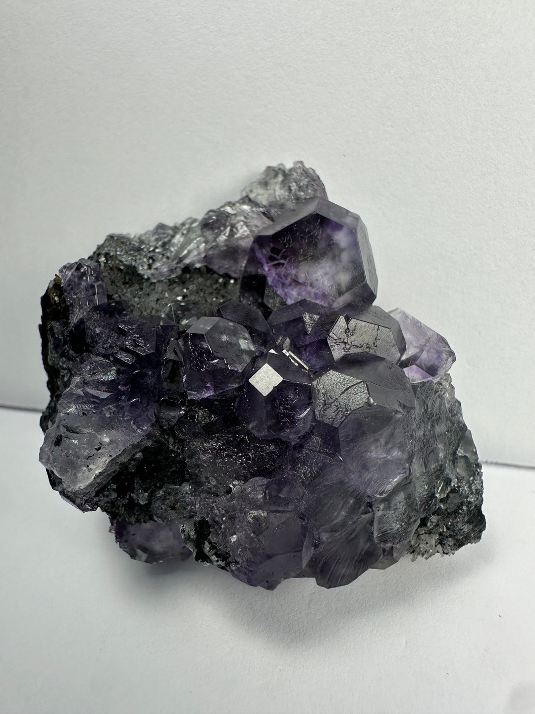 Dark mineral matrix with prominent purple fluorite crystal cluster